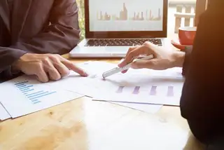 two people checking report graphs