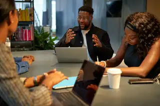 team discussing around laptops